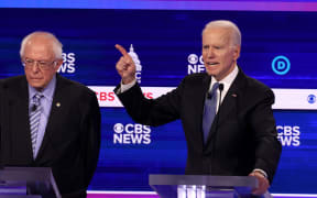Democratic presidential candidate former Vice President Joe Biden speaks as Bernie Sanders looks on during the debate at the Charleston Gaillard Center on February 25, 2020.