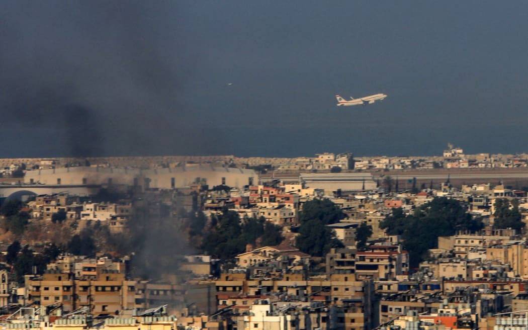 A Middle East Airlines commercial aircraft taking off from Beirut's international airport, amid smoke billowing above the Lebanese capital's southern suburbs, after Israeli strikes, on 28 September, 2024.