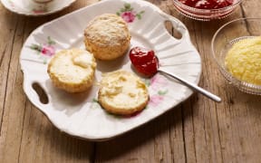 Afternoon tea of with fresh baked scones with jam and clotted cream (Photo by Tim MacPherson / Cultura Creative / Cultura Creative via AFP)