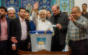 Saeed Jalili, Ultraconservative former nuclear negotiator, and Iran's presidential candidate waves to the crowd after casting his vote at a polling station in Tehran during Iran's presidential election on June 28, 2024. Around 61 million Iranians are eligible to vote in the snap presidential election to choose the next president after the death of Ebrahim Raisi in a helicopter crash. (Photo by Hossein Beris / Middle East Images / Middle East Images via AFP)