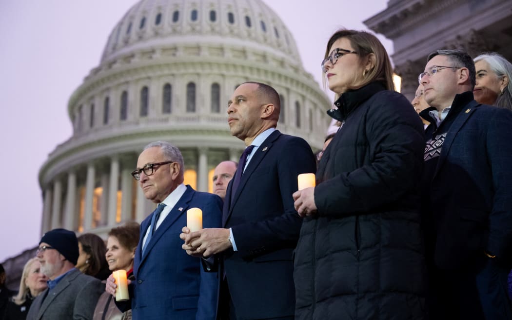 US House Minority Leader Hakeem Jeffries, Democrat of New York, and US Senate Minority Leader Chuck Schumer, Democrat of New York, lead Democratic members of Congress and family members of fallen US Capitol Police officers in a moment of silence marking the fifth anniversary of the January 6, 2021 attacks on the US Capitol, outside the US Capitol in Washington, DC, on January 6, 2026. (Photo by SAUL LOEB / AFP)
