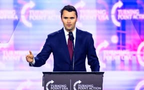 US right-wing activist Charlie Kirk speaking on stage at an event in 2024