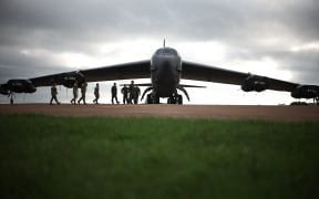 Flight crew from US Air Force 501st Combat Support Wing and 307th Bomb Wing walk towards a B-52 Stratofortress bomber aircraft at RAF Fairford on September 19, 2025.