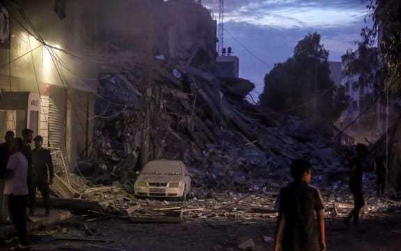A Palestinian boy standing in front of the wreckage left after Israeli air strikes destroyed this 14-storey residential tower in the Al-Rimal neighborhood of Gaza City.