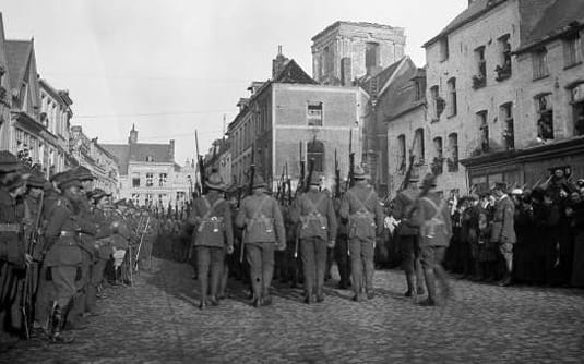 New Zealand troops marching through Le Quesnoy on 10 November 1918.