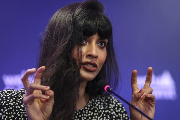Podcast host, actress and activist Jameela Jamil speaks into a microphoen.