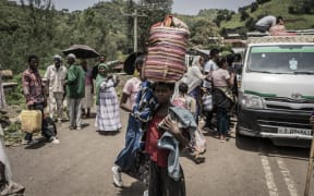 A girl carries her belongings in a basket as she flees flighting between the Ethiopian National Defence Force and Tigray People's Liberation Front, Zarima, 140km from Gondar, Ethiopia, on 16 September 2021.