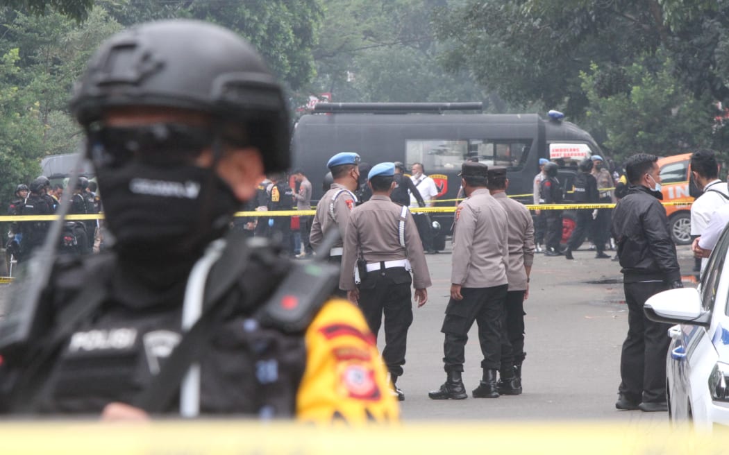 Police officers stand guard on a road near the scene suicide bombing attack in Bandung, Indonesia.