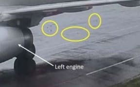 Foreign object debris on the ground behind the aircraft (circled).