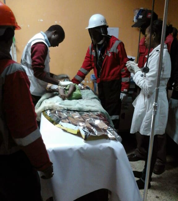 Kenyan Red Cross staff check a six-month-old baby rescued alive from the rubble of a six-storey building.
