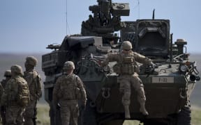 US Army serviceman jumps from armored vehicle during the NATO "Wind Spring 15" military exercise at Smardan military shooting range.