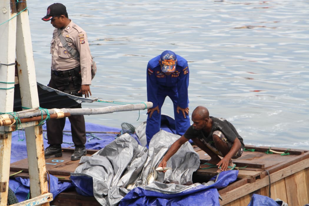 Indonesian police secure a vessel suspected of illegal fishing in West Papua waters.