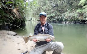 Fish and Game ranger Adam Daniel with a catch at Waipapa River.