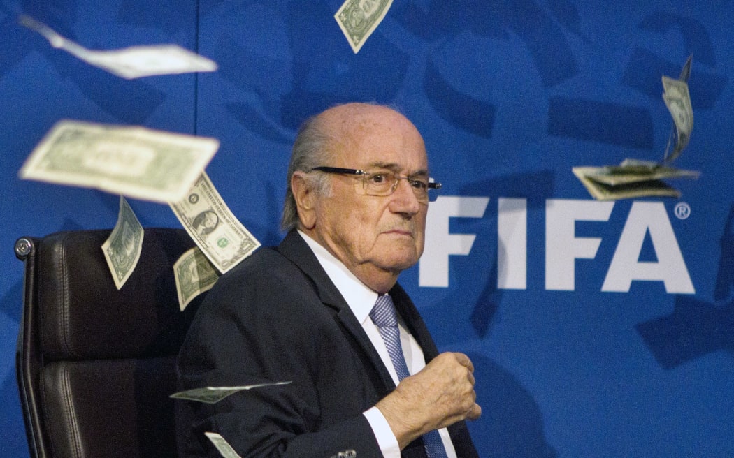 Dollar bills rain down on FIFA president Sepp Blatter, at a media conference in Zurich. A man posing as a journalist had thrown the money at him.
