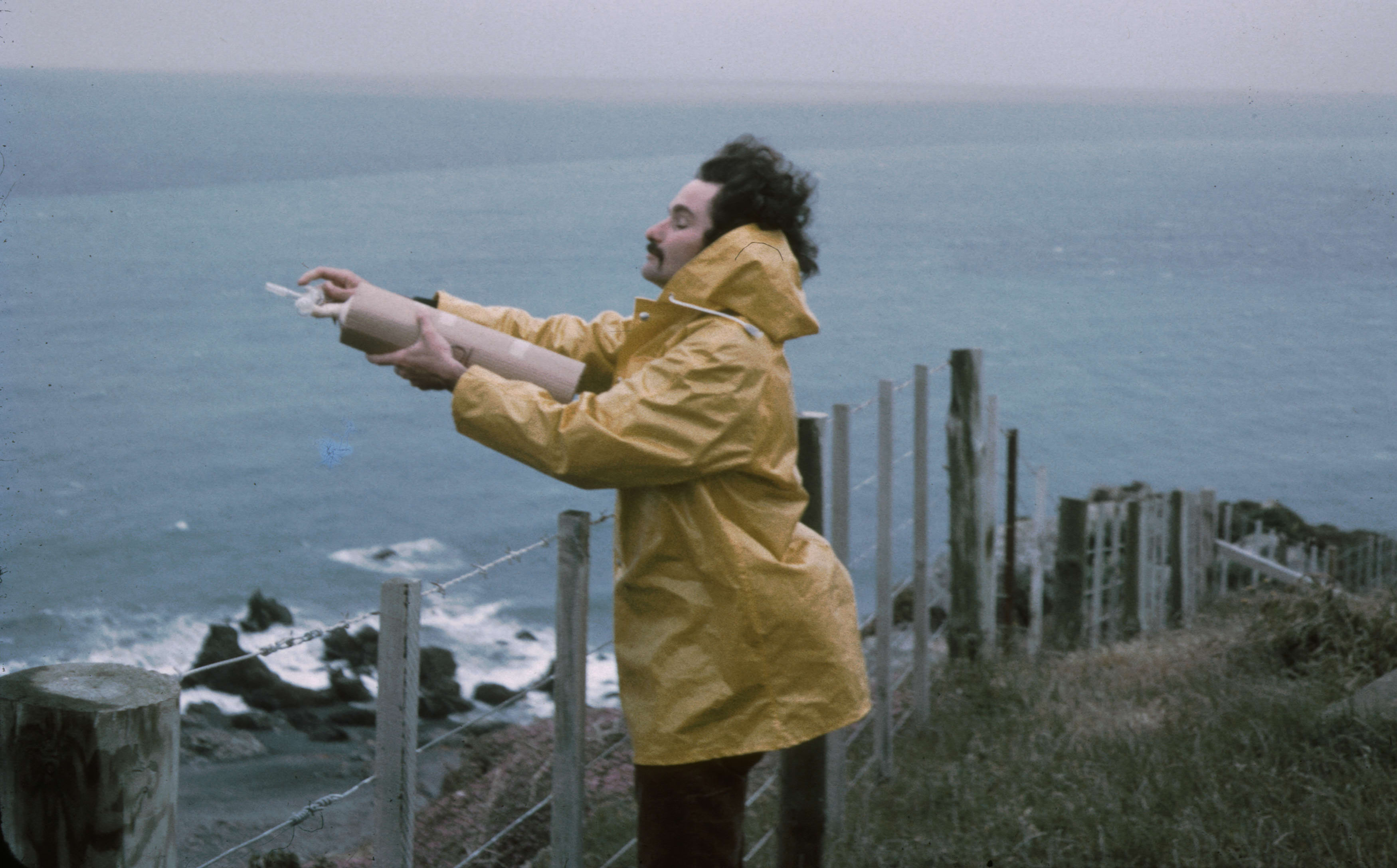 Dave Lowe taking an air flask sample at the edge of the Baring Head cliff in 1972.