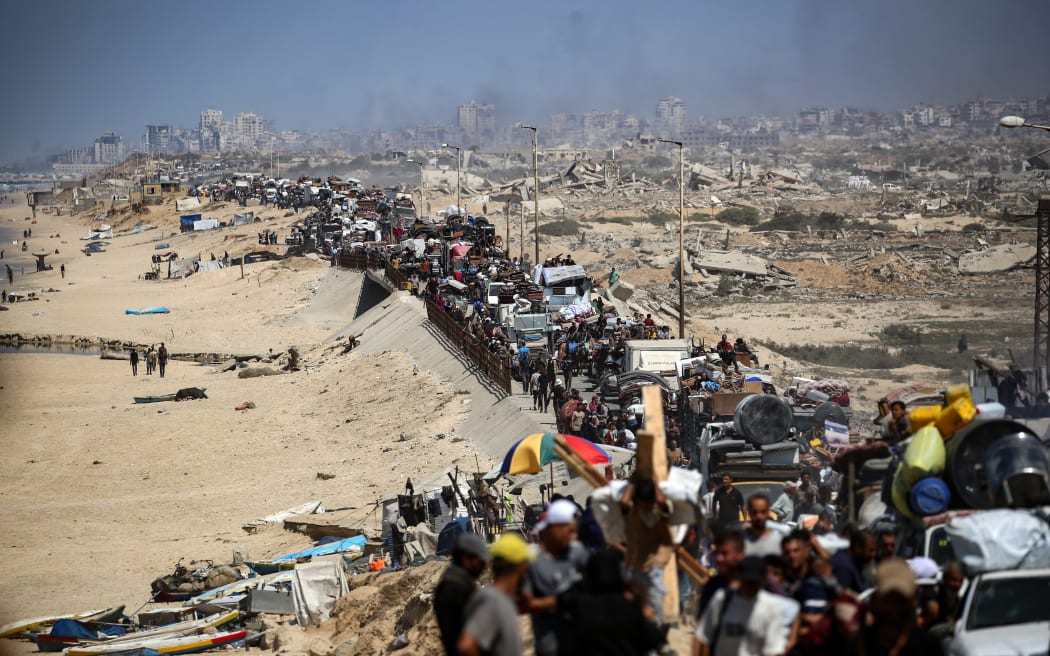 Palestinians from Gaza City move southwards with their belongings, on the coastal road near the Nuseirat refugee camp in the central Gaza Strip, on September 19, 2025. The Israeli military warned on September 19, that it will operate with "unprecedented force" in Gaza City, urging residents to flee southwards while announcing the closure of a temporary evacuation route opened 48 hours earlier. (Photo by Eyad BABA / AFP)