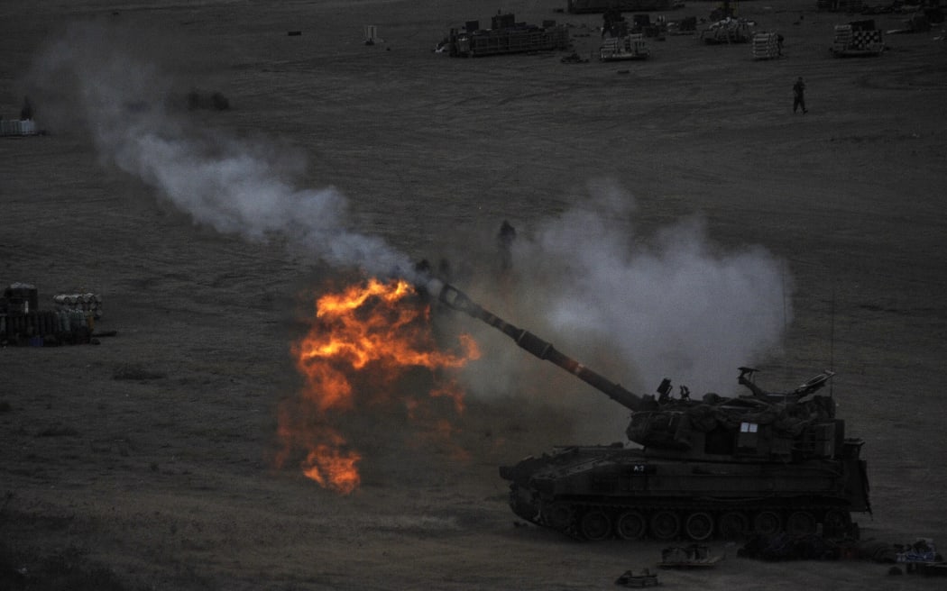 An Israeli tank fires a 155mm shell towards targets in the Gaza Strip from its position near Israel's border with the Palestinian enclave.