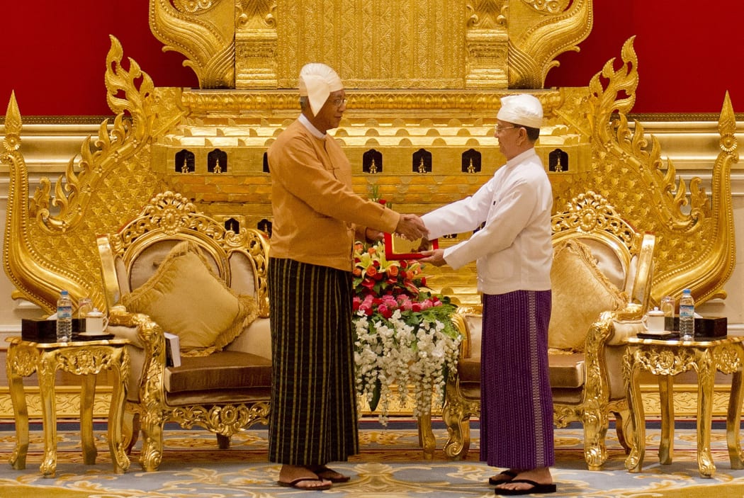 New Myanmar president Htin Kyaw, left, receives the presidential seal from outgoing president Thein Sein during the handover ceremony on 30 March.