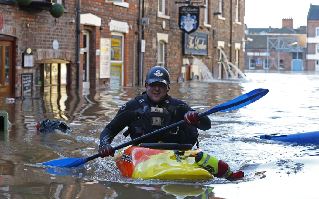 A police canoeist paddles along flooded streets in York city centre,