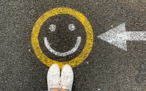 Smiley face sign on pavement denoting happiness