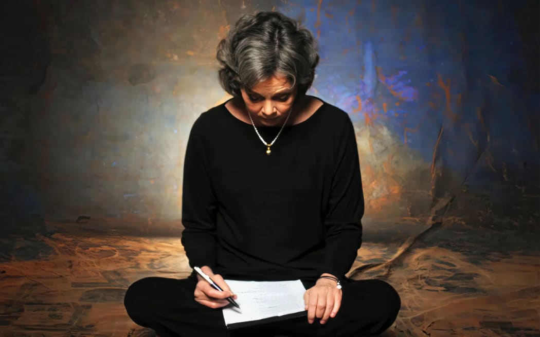 Cover image from the tribute album to American singer-songwriter Nancy Griffith, 'More than a Whisper'. Griffith sits cross-legged with pen and paper in hand.