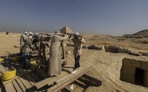 Egyptian antiquities workers at the Saqqara archaeological site on 26 January, 2023, where a gold-laced mummy and four tombs including of an ancient king's "secret keeper" were recently discovered, south of Cairo.