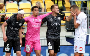 Phoenix goalkeeper Alex Paulsen and defenders Finn Surman (left) and Scott Wootton (right) celebrate victory over the Brisbane Roar at Sky Stadium in Wellington in March.