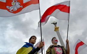 Members of the Belarus diaspora wave national flags during a "Free Belarus" rally at Independence Square in Kiev on August 1, 2020, a week before the Belarus presidential election.