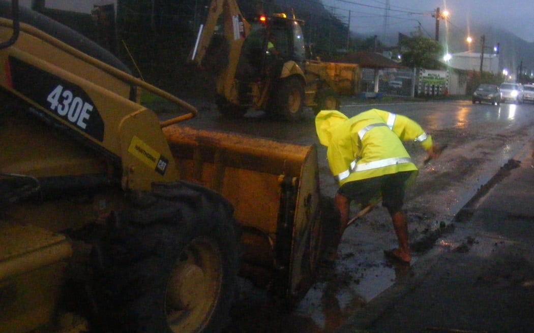 Contract workers early this morning in American Samoa, clearing mud and debris on the main highway on the main island of Tutuila, due to Tropical Cyclone Tuni