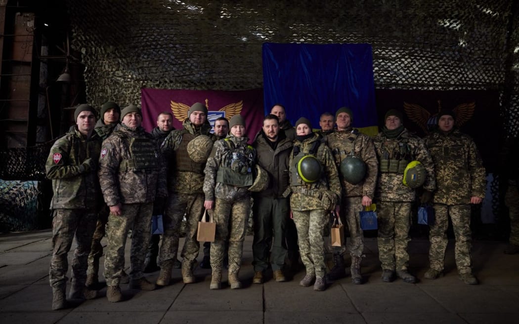This handout picture taken and released by the Ukrainian Presidential press service on December 6, 2022, shows Ukrainian President Volodymyr Zelensky (C) posing with Ukrainian soldiers as he visits the Donetsk region, amid the Russian invasion of Ukraine. - President Volodymyr Zelensky on December 6, 2022 visited the frontline region of Donetsk in east Ukraine, describing fighting in the area as "difficult" with Russian forces pushing to capture the industrial city of Bakhmut. "From the bottom of my heart, I congratulate you on this great holiday, the Day of the Armed Forces," said Zelensky, who was later shown meeting soldiers and distributing awards. (Photo by UKRAINIAN PRESIDENTIAL PRESS SERVICE / AFP) / RESTRICTED TO EDITORIAL USE - MANDATORY CREDIT "AFP PHOTO / UKRAINIAN PRESIDENTIAL PRESS SERVICE " - NO MARKETING NO ADVERTISING CAMPAIGNS - DISTRIBUTED AS A SERVICE TO CLIENTS