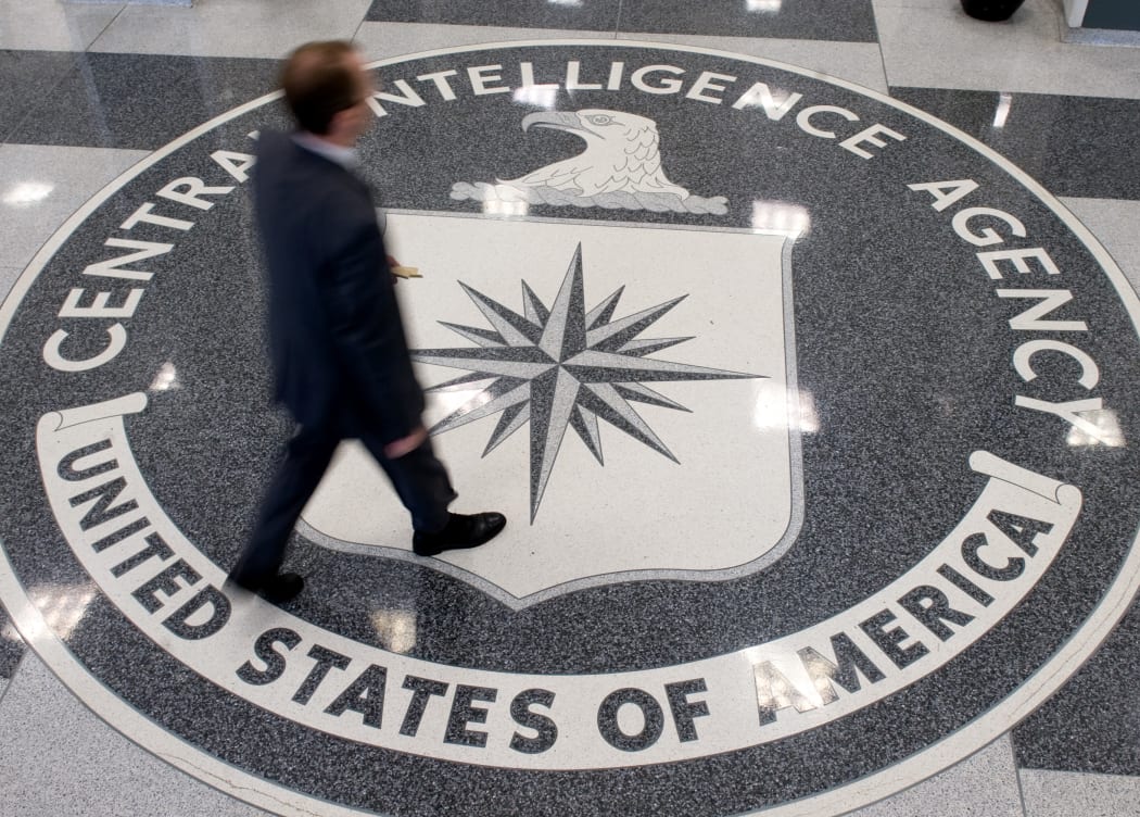A man walking across the Central Intelligence Agency (CIA) logo in the lobby of CIA Headquarters in Langley, Virginia.