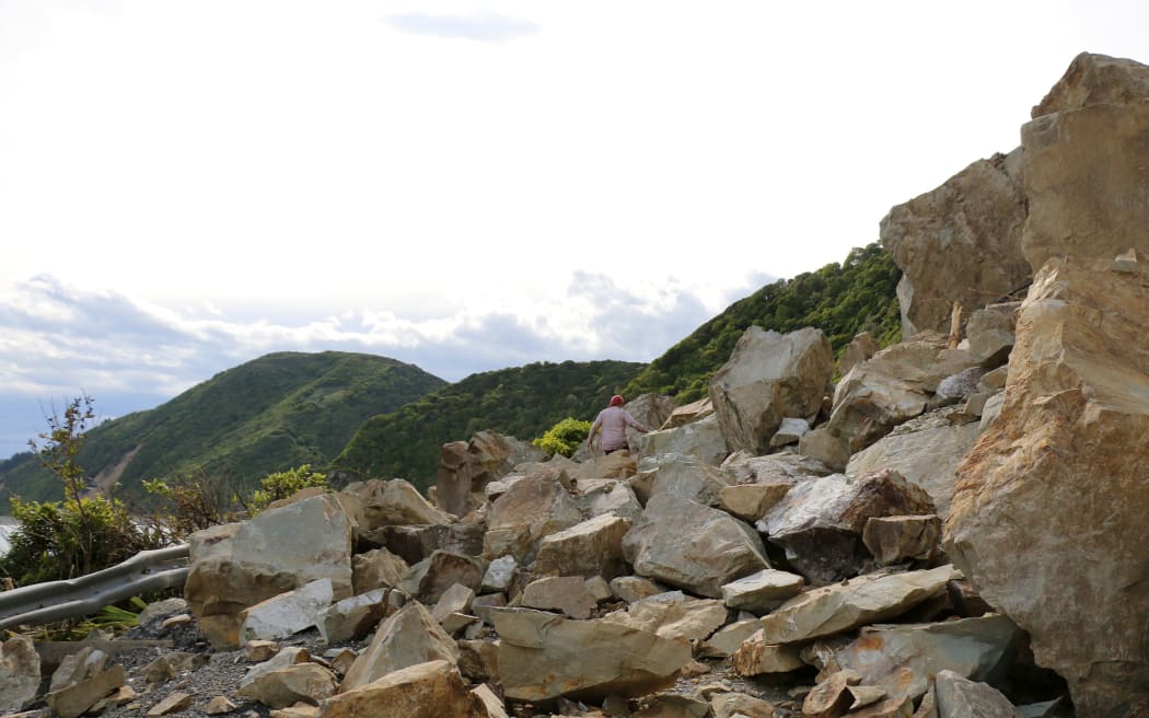 Pete clambers over an enormous slip to reach his house in the hills above the Kaikoura coast