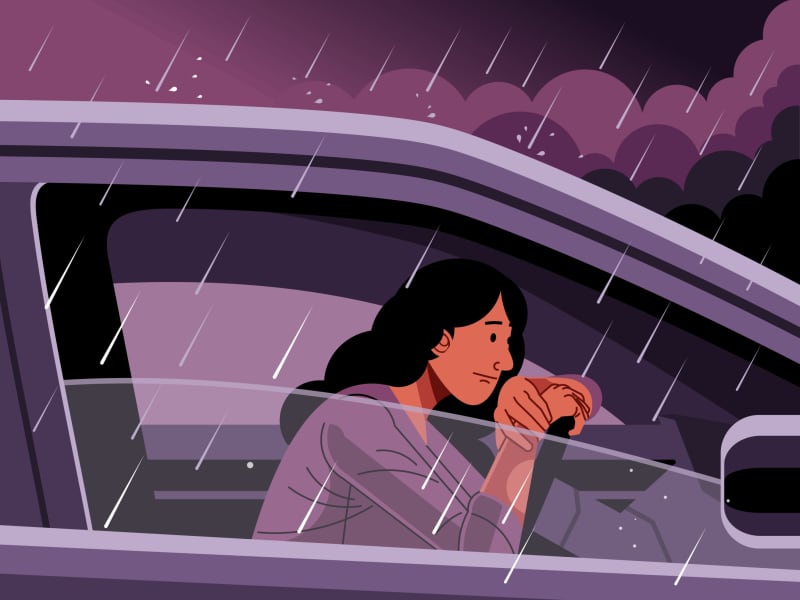 A person sitting in their car in a downpour of a thunderstorm, bad weather, rain.