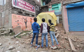 Children look towards a damaged residential structure in Srinagar, the summer capital of Indian-controlled Kashmir.