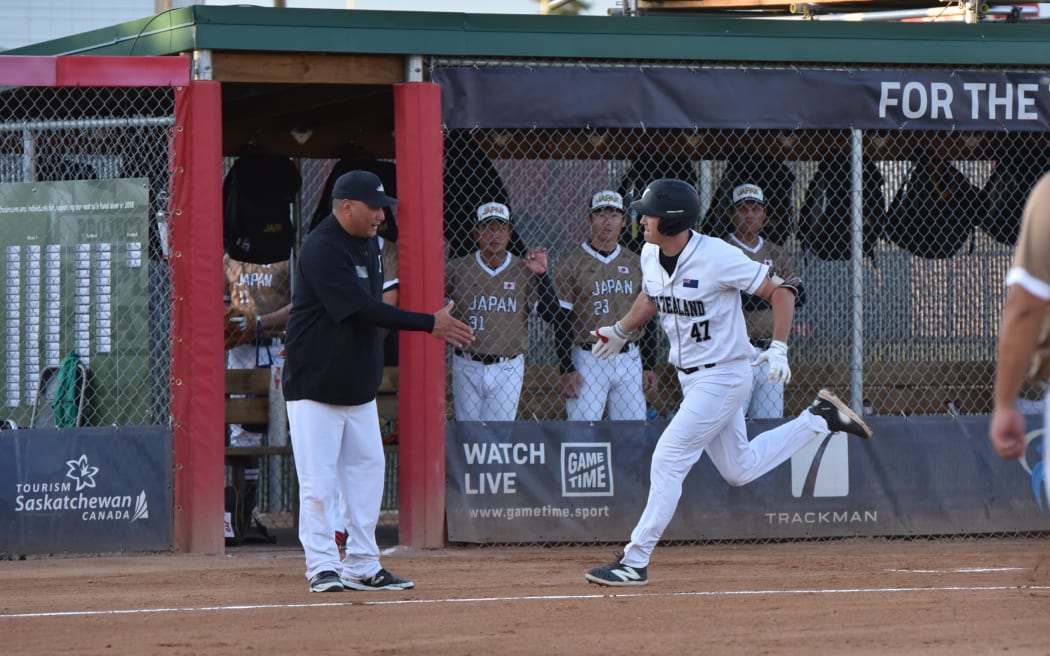 Black Sox team captain Cole Evans celebrates with head coach Thomas Makea after powering a ball over centre-field fence.