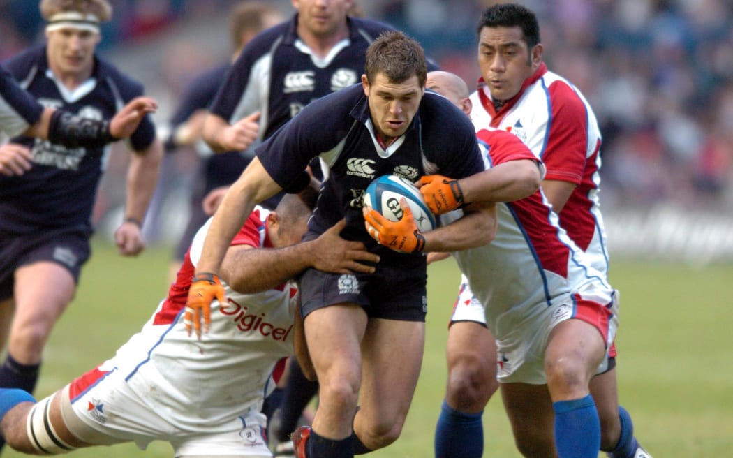 Simon Raiwalui (L) attempts to tackle Scotland's Sean Lamont while playing for the Pacific Islanders in 2006.