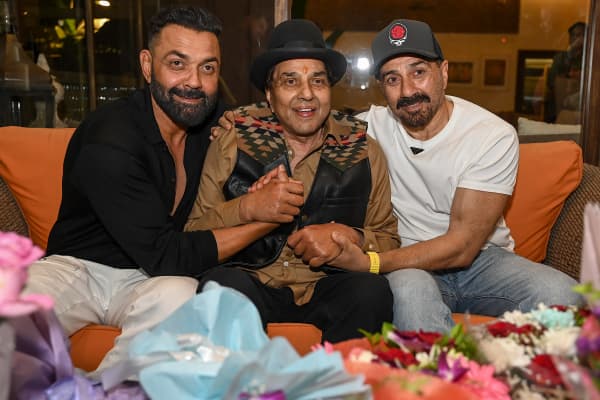Bollywood actor Dharmendra (C) along with his sons Sunny Deol (R) and Bobby Deol poses for a photo on the occasion of his 89th birthday at his residence in Mumbai on December 8, 2024.