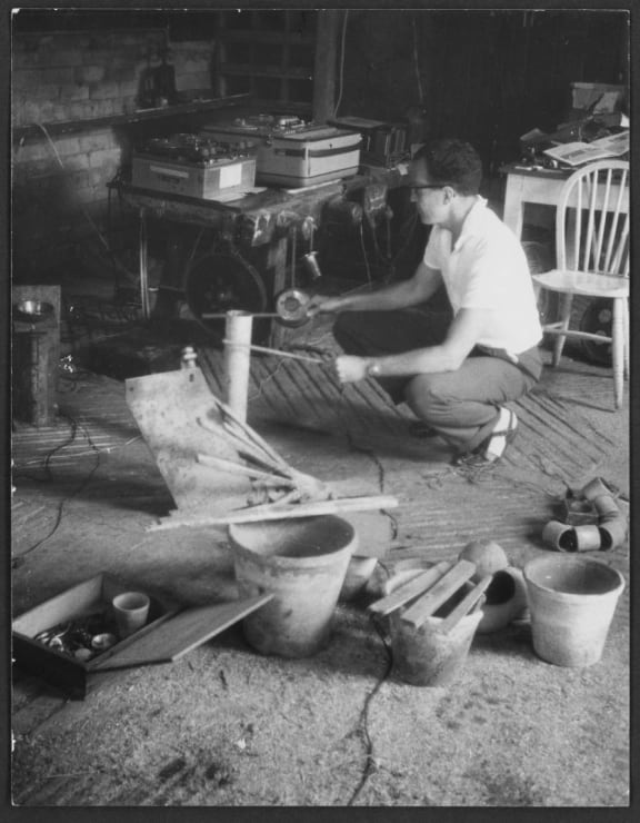 Douglas Lilburn recording the sound of struck sheets of steel and other items on to magnetic tape, in a barn in Wiltshire, England, circa 1963.