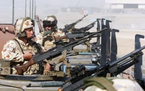 Australian soldiers of the NATO-led International Security Assistance Force (ISAF) keep guard on top of armored vehicles, in Tirin Kot, the capital of Uruzgan province, Afghanistan, on February 17, 2007.