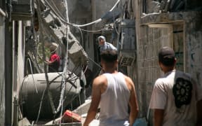 Palestinians inspect the destruction of an Israeli airstrike on a residential neighborhood in Bureij refugee camp, central Gaza, Thursday, August 8, 2024. The United States, Qatar, and Egypt are calling for a new round of ceasefire talks following escalating tension in the region. (Photo by Saeed Jaras / Middle East Images / Middle East Images via AFP)