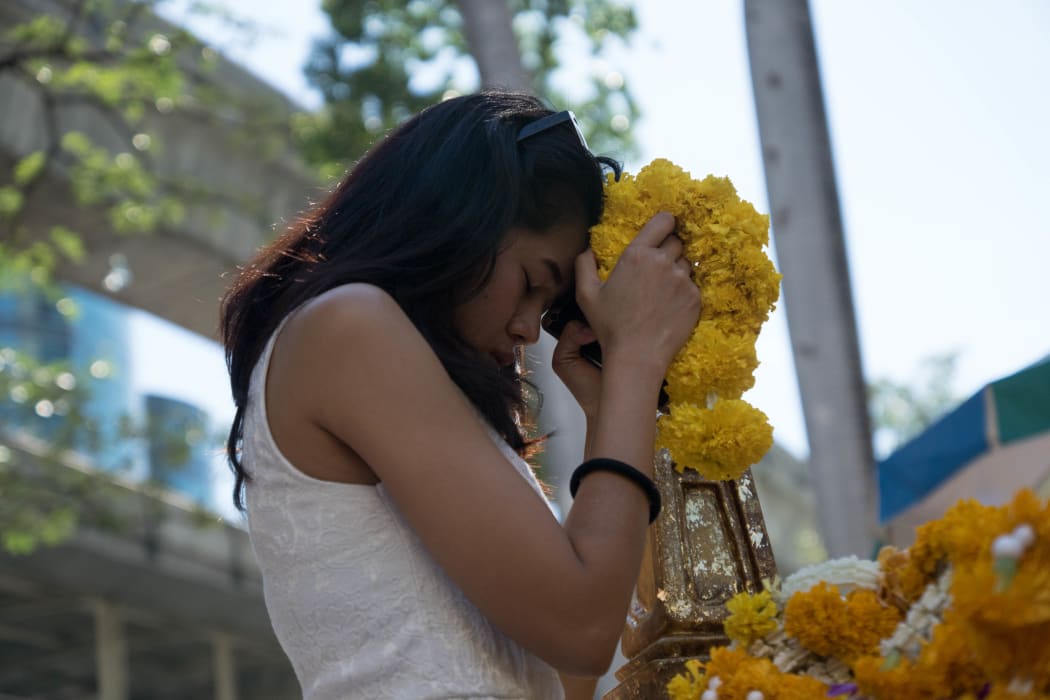 A woman prays at the reopened Erawan Shrine in Bangkok.