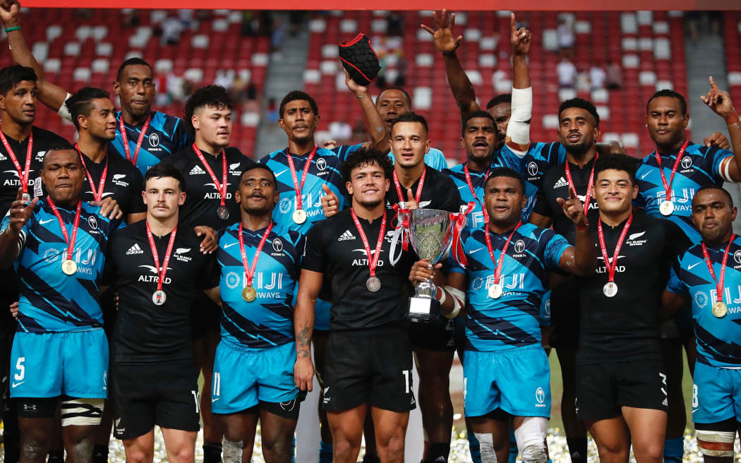 Players pose for a team photo afer Fiji won the 2022 Singapore tournament against New Zealand All Black Sevens.