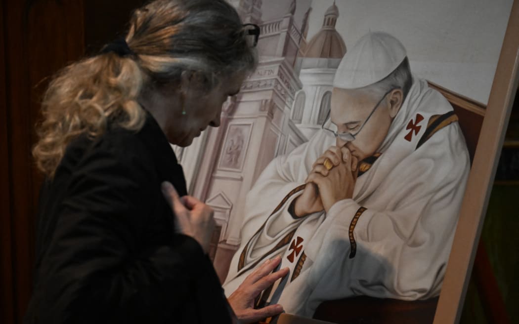 A faithful Catholic prays at Basilica San Jose de Flores in Buenos Aires on April 21, 2025, following the death of Pope Francis in the Vatican. The Basilica de San Jose de Flores was the church where Pope Francis was inspired to consecrate his life to God and the Catholic Church. Pope Francis died on April 21, 2025 aged 88, a day after making a much hoped-for appearance at Saint Peter's Square on Easter Sunday, the Vatican said in a statement. (Photo by Luis ROBAYO / AFP)