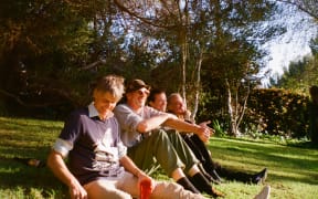 Members of The Hard Quartet sitting on the grass laughing