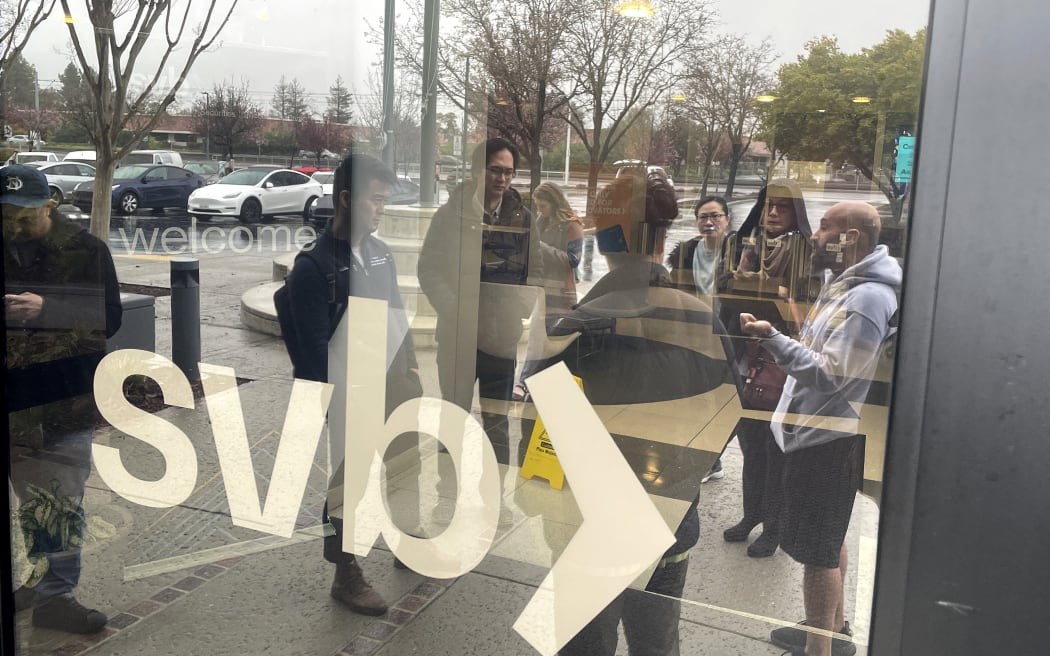 People line up outside the shuttered Silicon Valley Bank (SVB) headquarters on 10 March, 2023 in Santa Clara, California.
