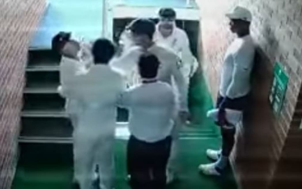 An image from video footage showing Australian players holding David Warner back during an altercation with South Africa's Quintin de Kock.