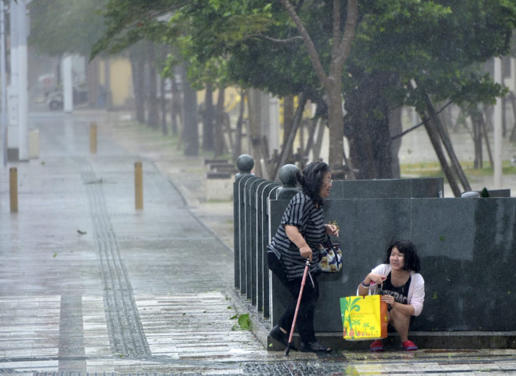 Women caught in the typhoon's strong winds in Naha on the southern island of Okinawa on  Tuesday.