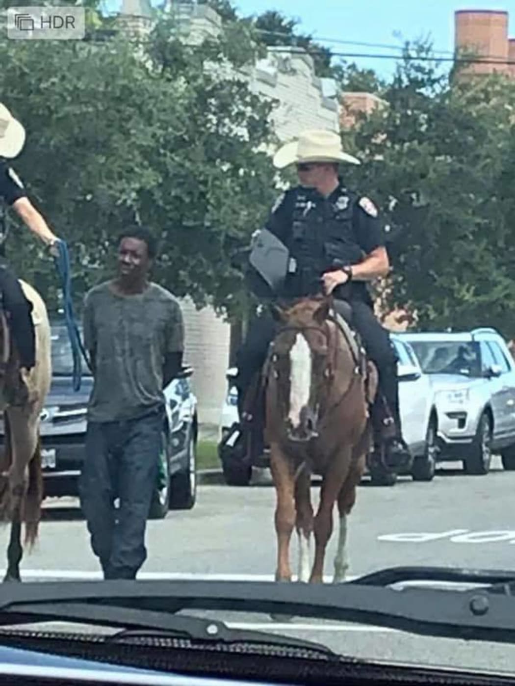 blacTexas police have apologised after an image of two white officers on horseback leading a handcuffed k man by a rope caused an outcry online.