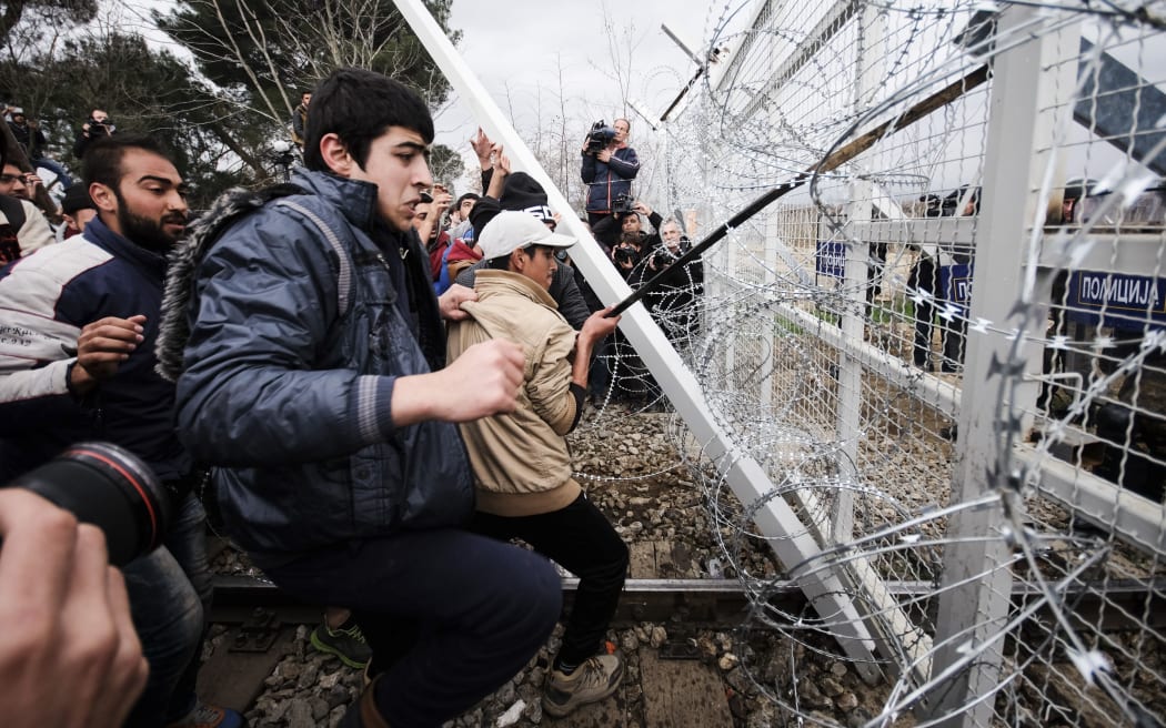 Migrants pushing against a fence at Idomeni in Greece.