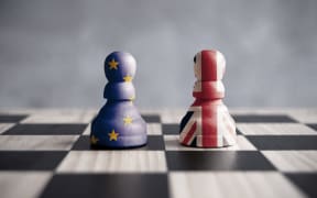 Two chess pawns with UK and European flags